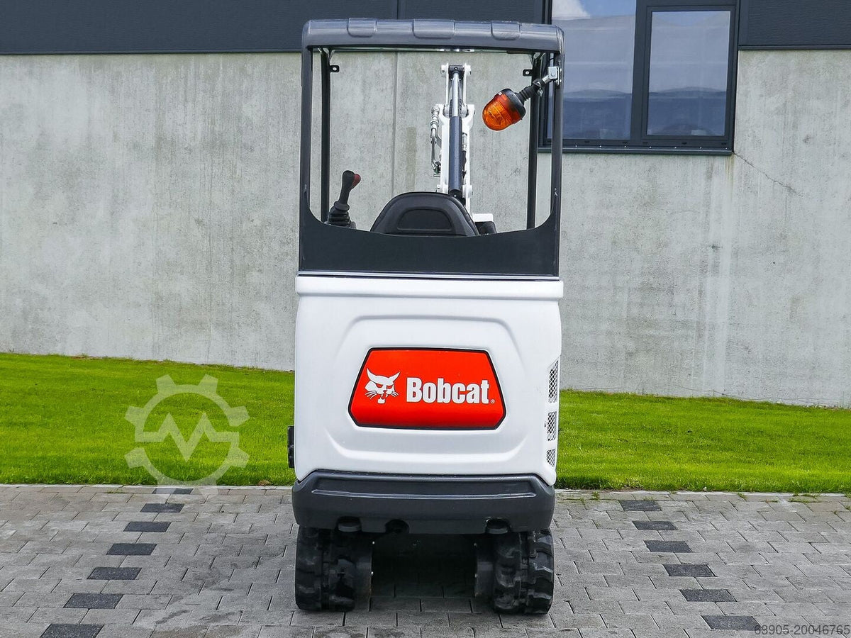 Mini-pelle Ma boutique Bobcat E17 blanche vue de l'arrière sur un chantier avec gyrophare orange