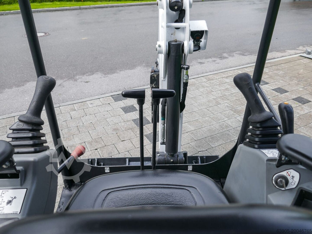 Vue depuis le poste de conduite de la mini-pelle Ma boutique Bobcat E17 montrant les commandes et le bras articulé