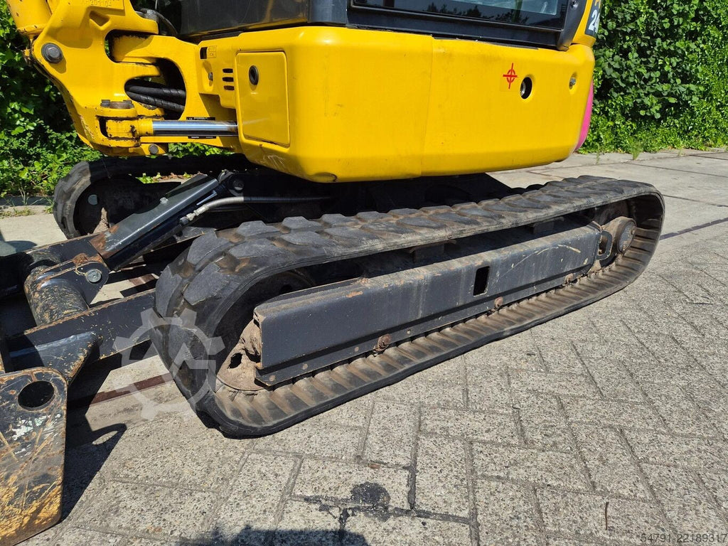 Mini-pelle Ma boutique Komatsu PC24MR-5 jaune avec train de roulement sur chenilles en caoutchouc sur sol pavé