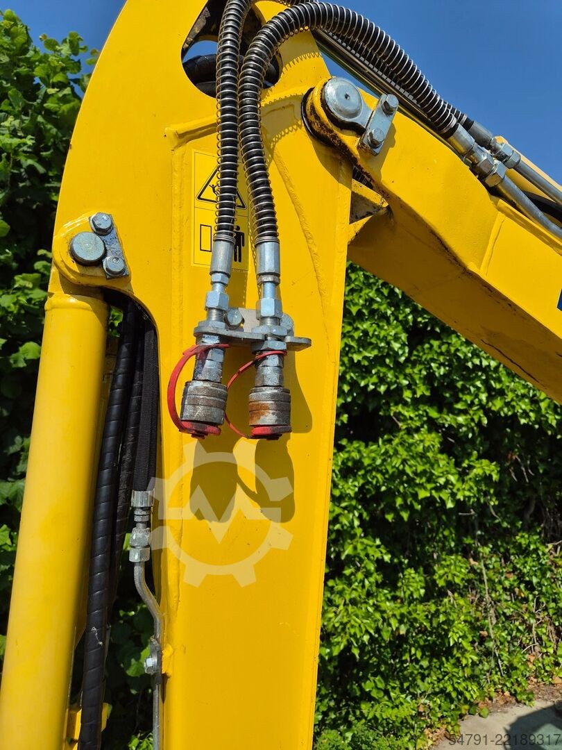 Détail du circuit hydraulique auxiliaire sur le bras jaune d'une mini-pelle Komatsu PC24MR-5 chez Ma boutique